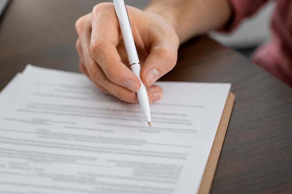 Personas firmando un documento.